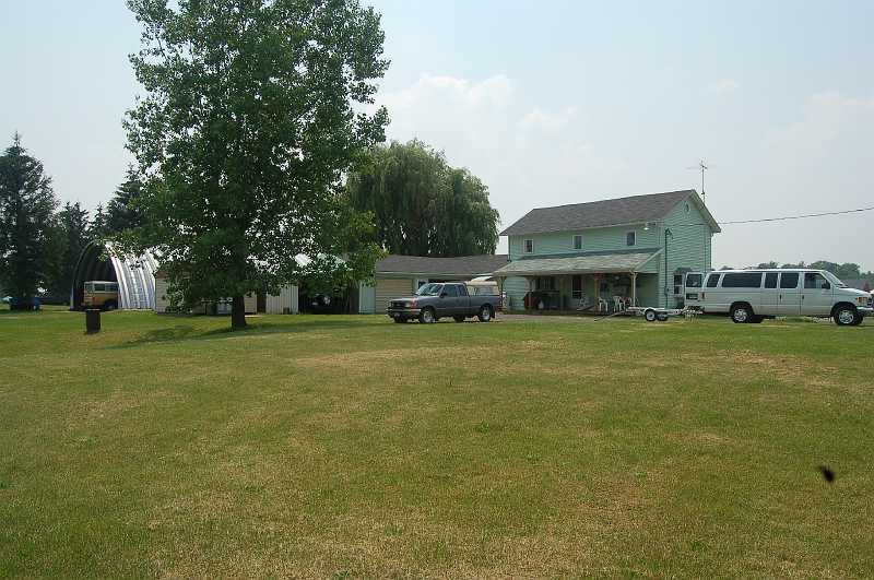 Canada East Tour 2006181.JPG - The original house was built in the early 1800s, and has been updated by Al & Janet in the 30 years they have lived there.  Al keeps his plane in the hangar to the left of the house and his shop is in the low buildings between the hangar and the house.